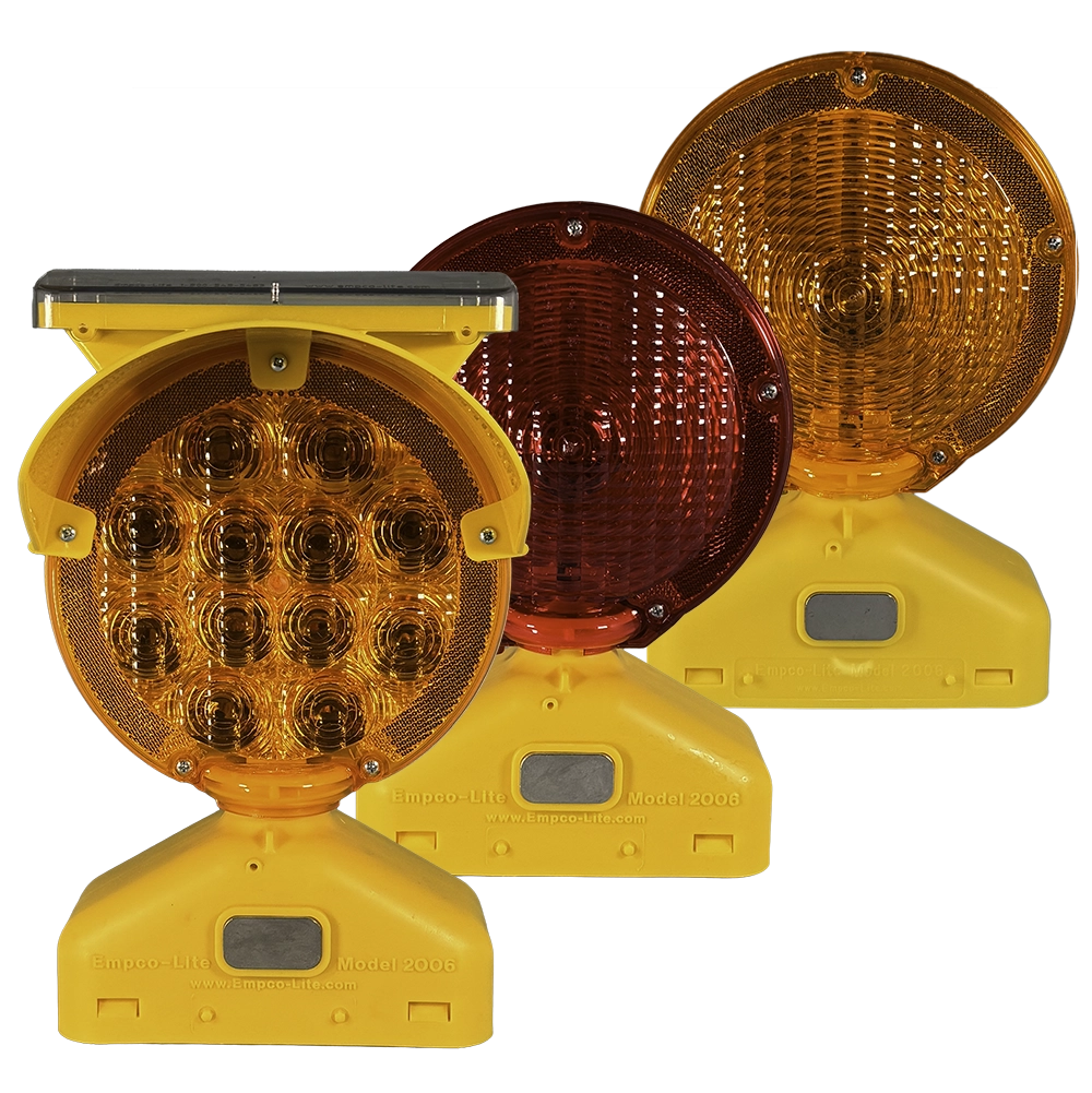 A product photograph displaying three Empco-Lite Model 2006 barricade warning lights in different configurations — a solar-powered LED model, a dual-lens amber and red model, and a battery-powered amber Fresnel model — all mounted on yellow plastic bases. Classified under MUTCD Part 6K, barricade warning lights provide flashing or steady-burn amber illumination to supplement barricades and channelizing devices during nighttime and low-visibility conditions in temporary traffic control zones.