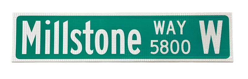 A green extruded street name signs with block numbers. 