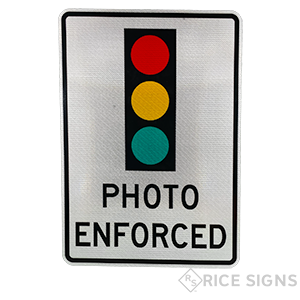 This is a picture the photo enforced sign.  The sign shows a symbol of a traffic signal and has the words PHOTO ENFOCED at teh bottom in black letters