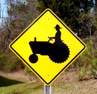 A picture of our tractor road sign. The tractor road sign shows the symbol of a tractor and is mounted on an optional u-channel highway post.