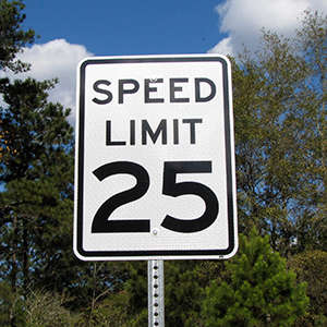 Picture of an aluminum speed limit sign that is installed on a pole on a local street.