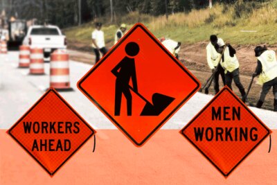 A road construction workzone with multiple workers and several MUTCD workers signs